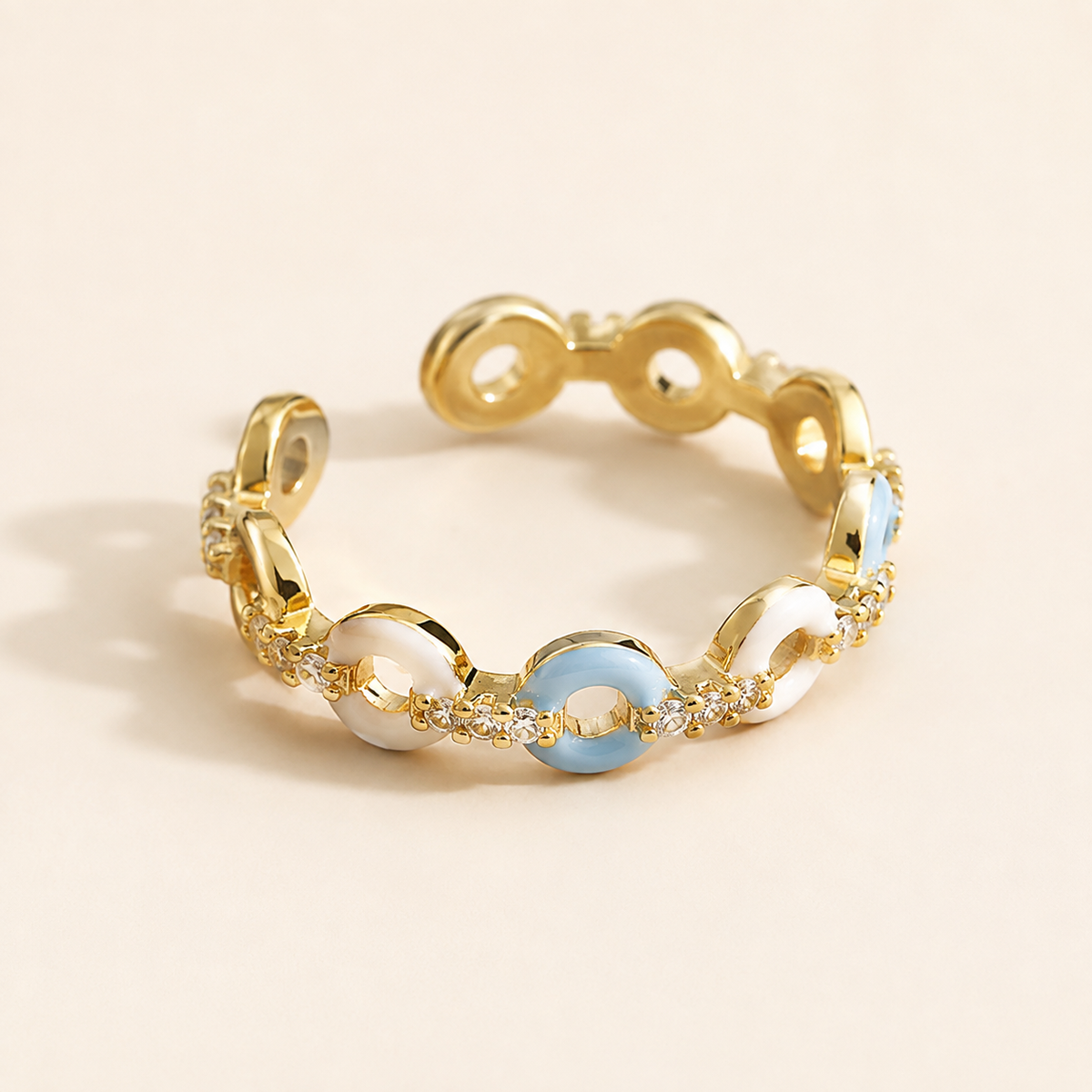 Close view of the pale-blue and ivory links, clear-looking accent points, and open terminals of the Azure Talisman Open Ring.