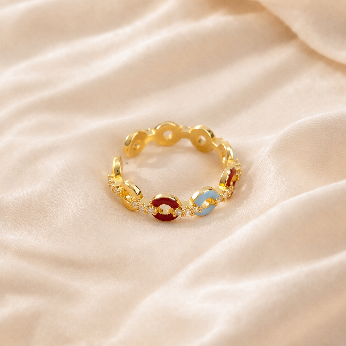 Carmine Cadence Open Ring with crimson and pale-blue links on cream silk