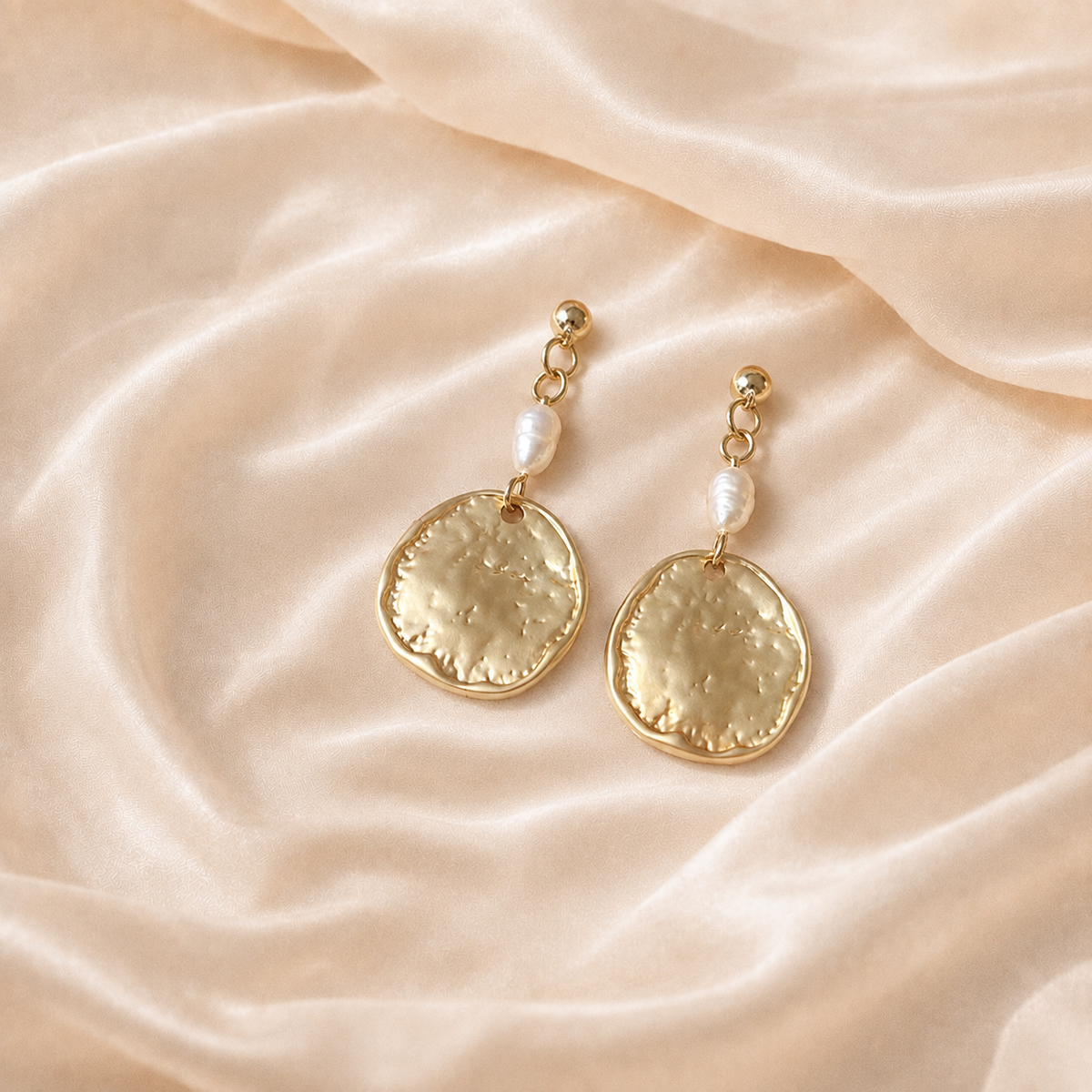 Dappled Disc Pearl Drop Earrings with pale oval pearl elements and textured round drops on cream silk