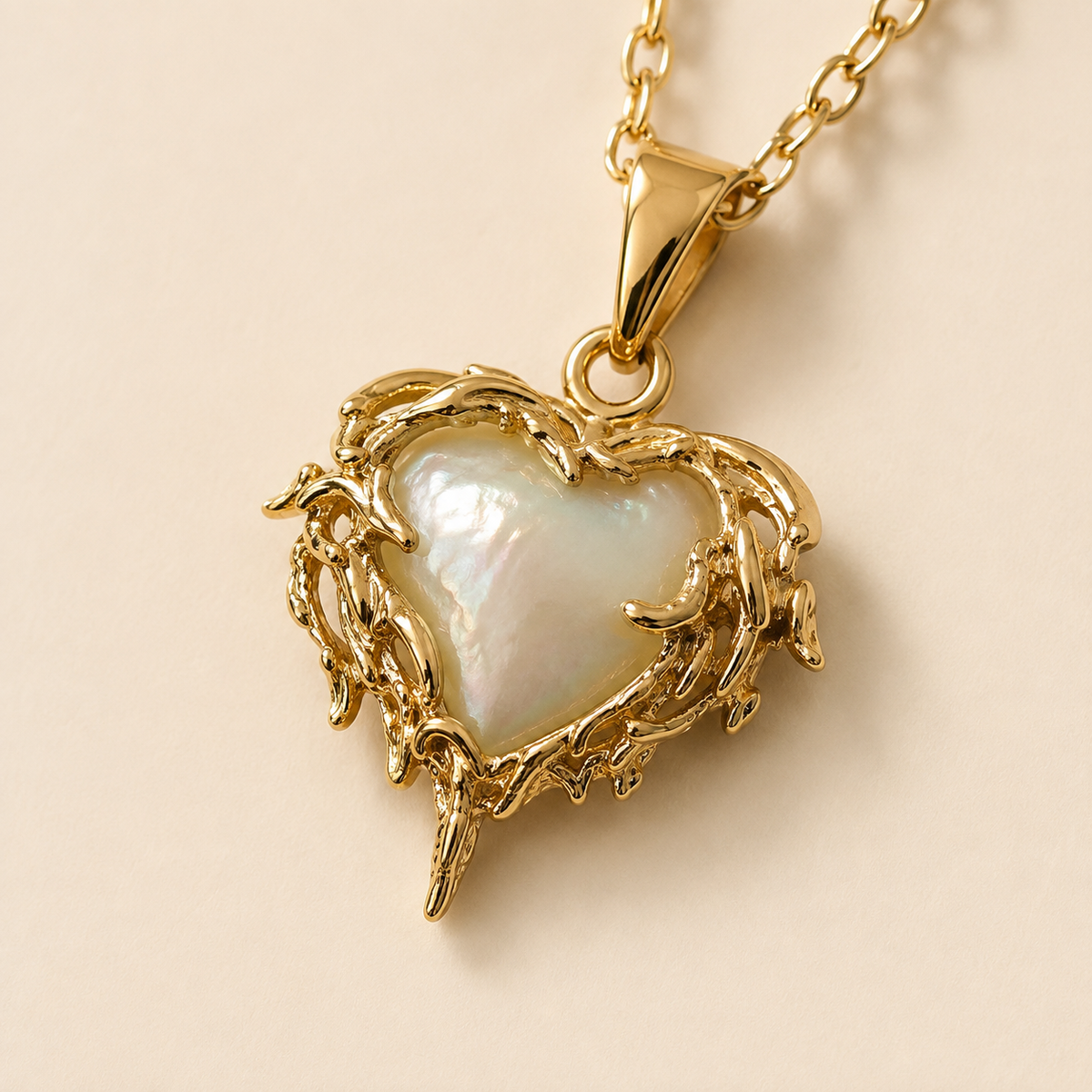 Close view of the Candlelit Flame Pendant Necklace, showing its ornate gold-toned frame, pale heart centre, bail, and connector.