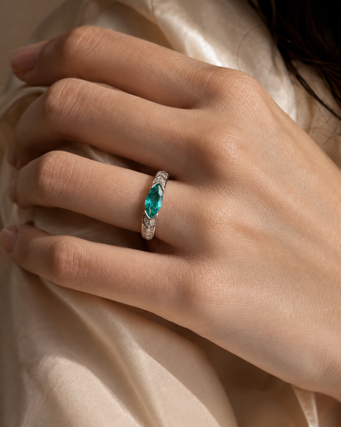 Hand wearing the Lagoon Spire Ring with its vertical blue-green center in view
