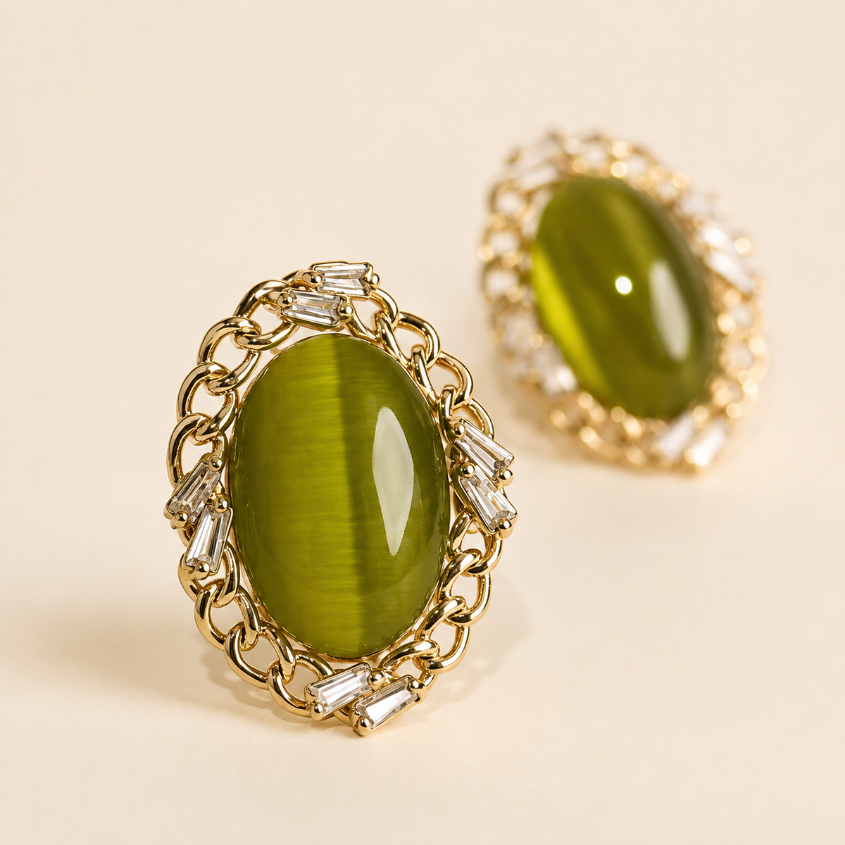 Close view of a green oval stud-front earring with metallic border details