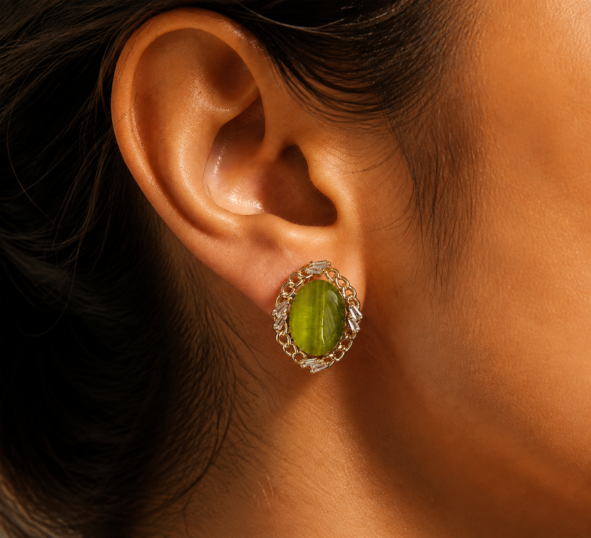 Green oval stud-front earring worn in a close ear view