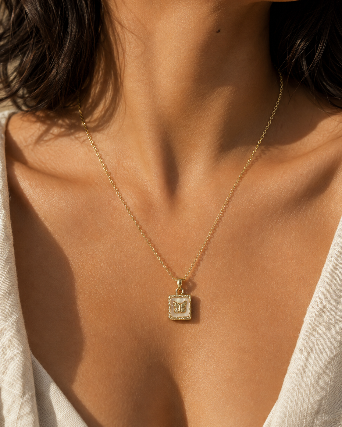 Butterfly Memento Pendant Necklace worn at the neckline, showing the vertical rectangular pendant.