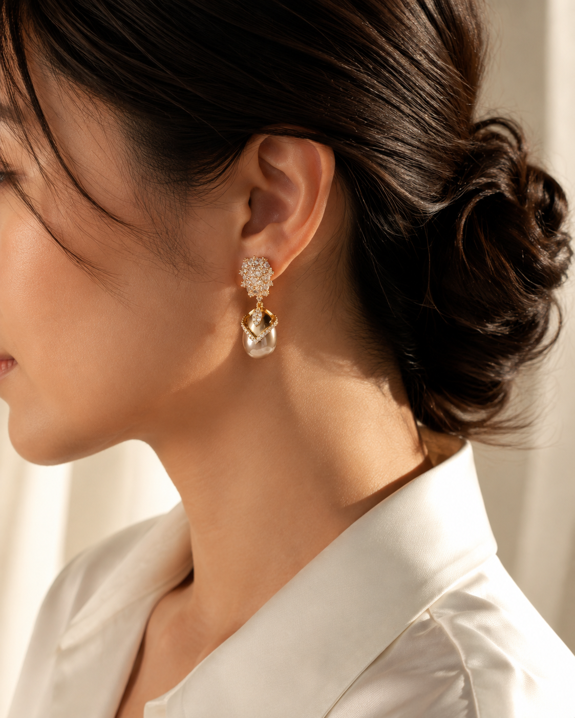 Editorial wearing view of Misted Votive Earrings with warm yellow-gold-tone frames and champagne-colored pearl drops.