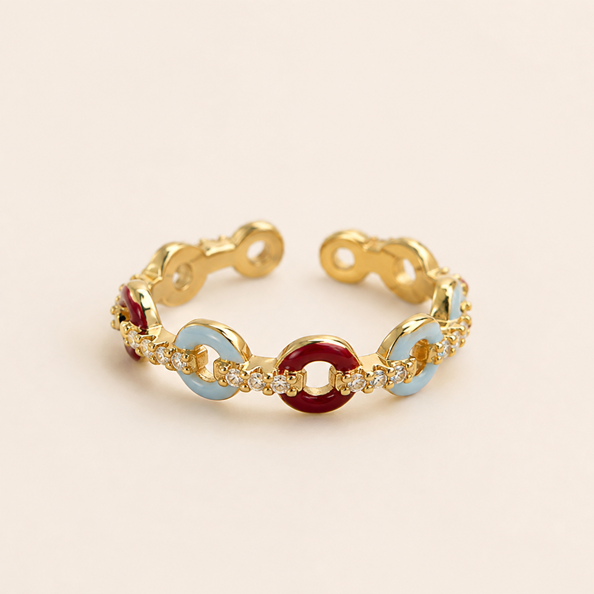 Close-up of the Carmine Cadence Open Ring with a warm gold-toned open band and rounded colored links