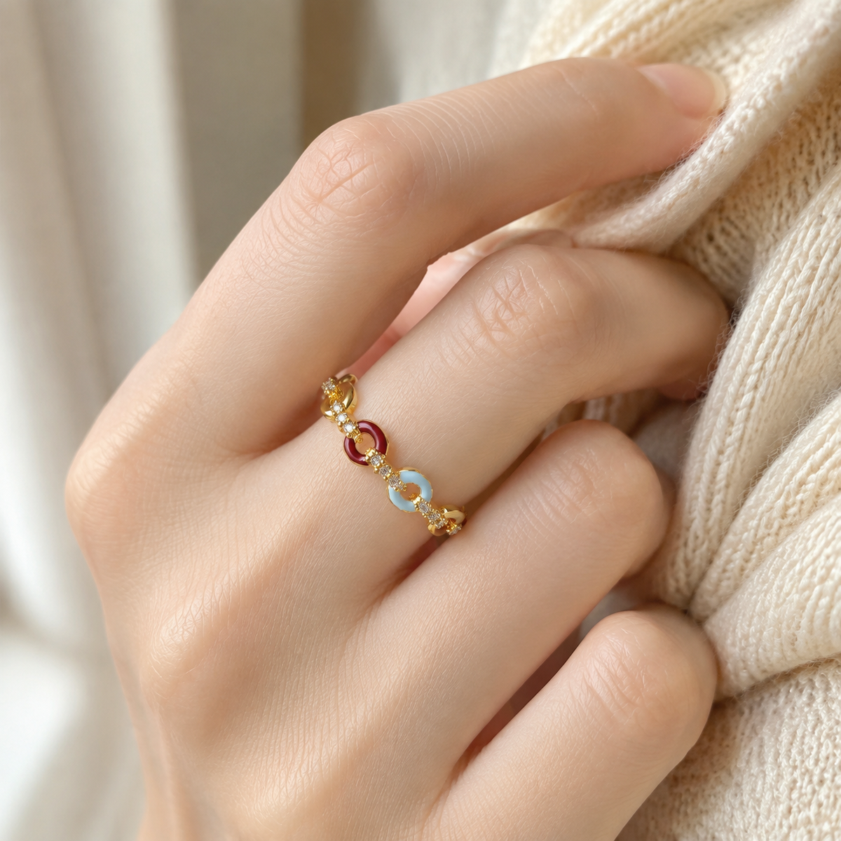 Carmine Cadence Open Ring worn on a hand, showing its rounded crimson and pale-blue front links