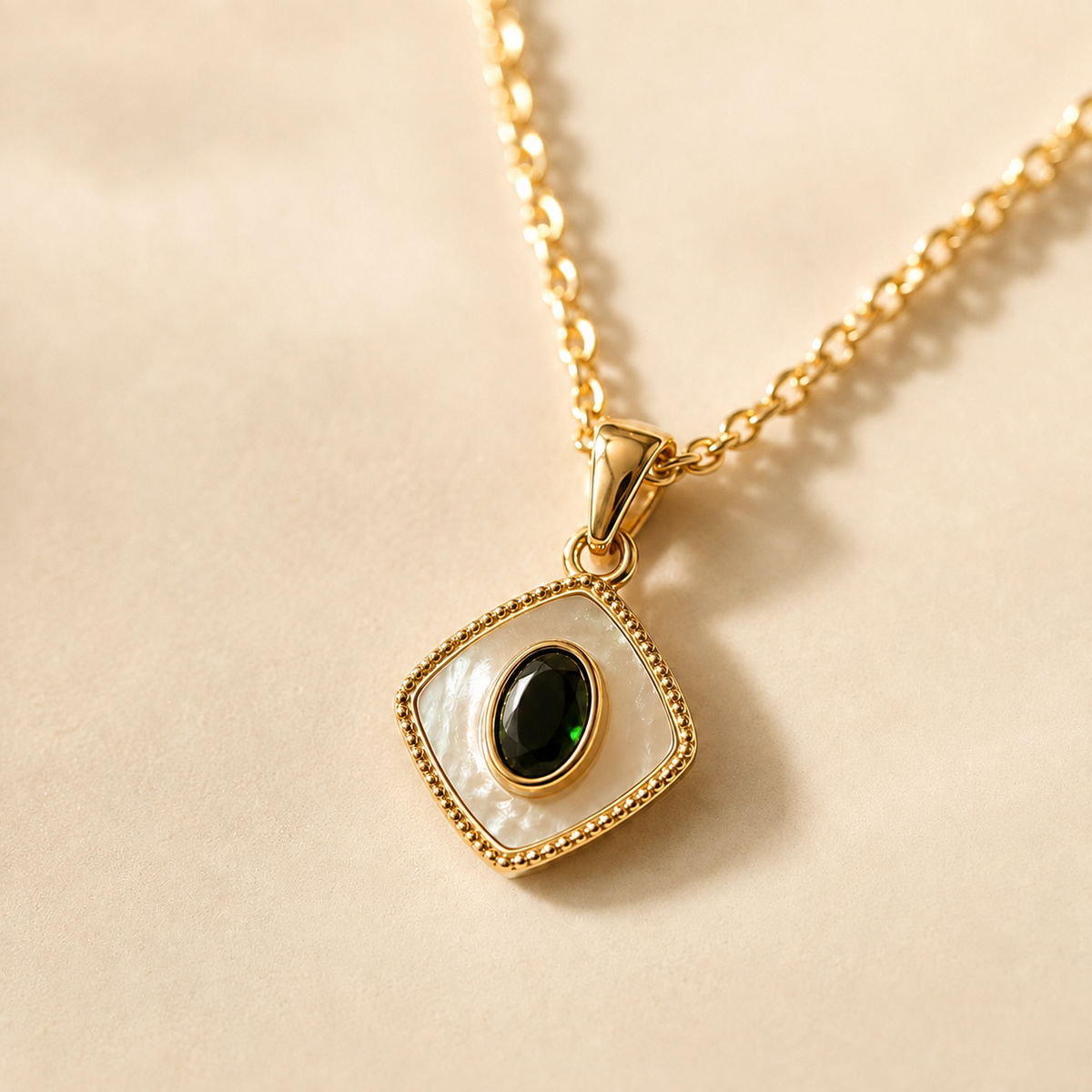 Close view of the diamond-shaped pale pendant with a glossy dark oval center and textured gold-toned border.