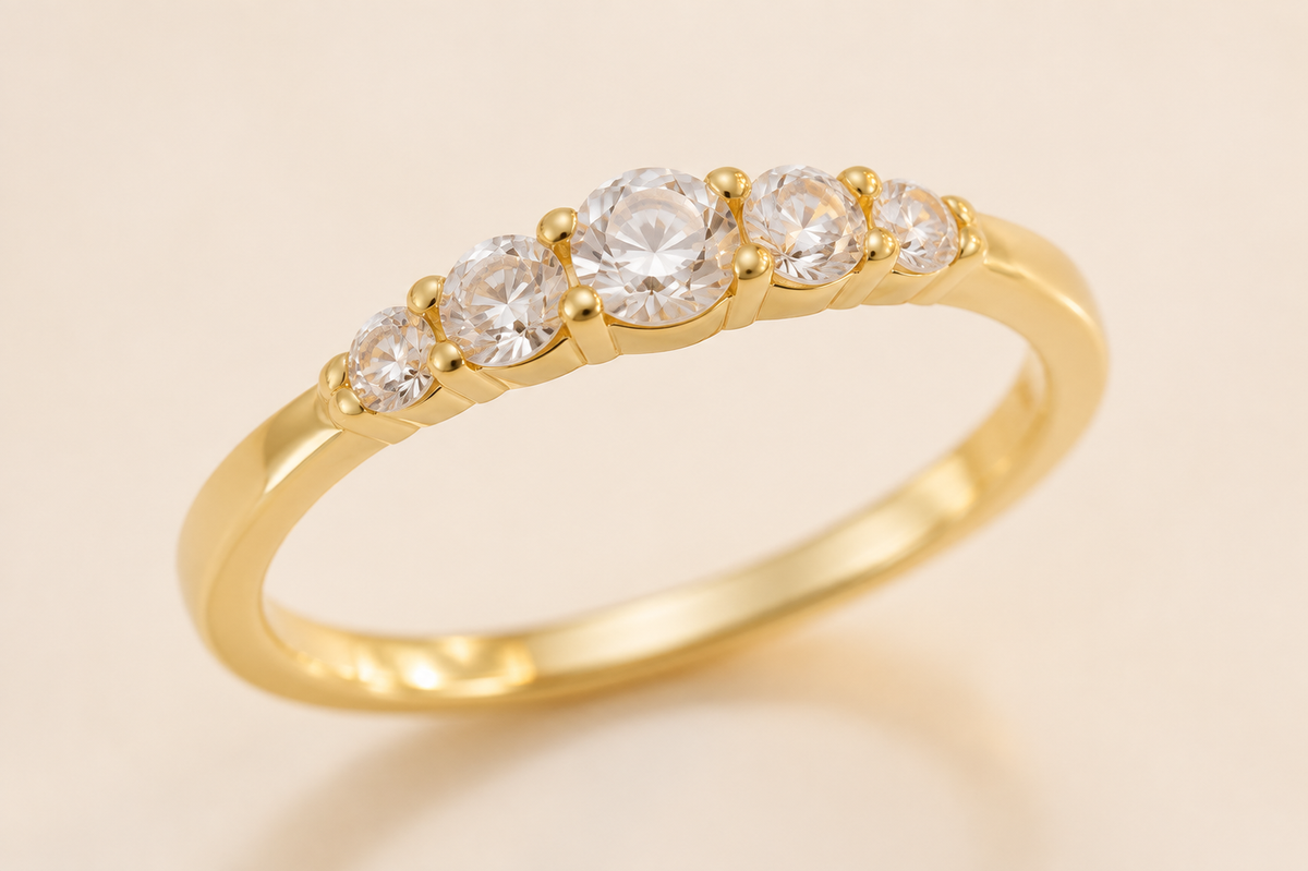 Close view of a slim closed ring with five graduated zircon accents and visible prongs