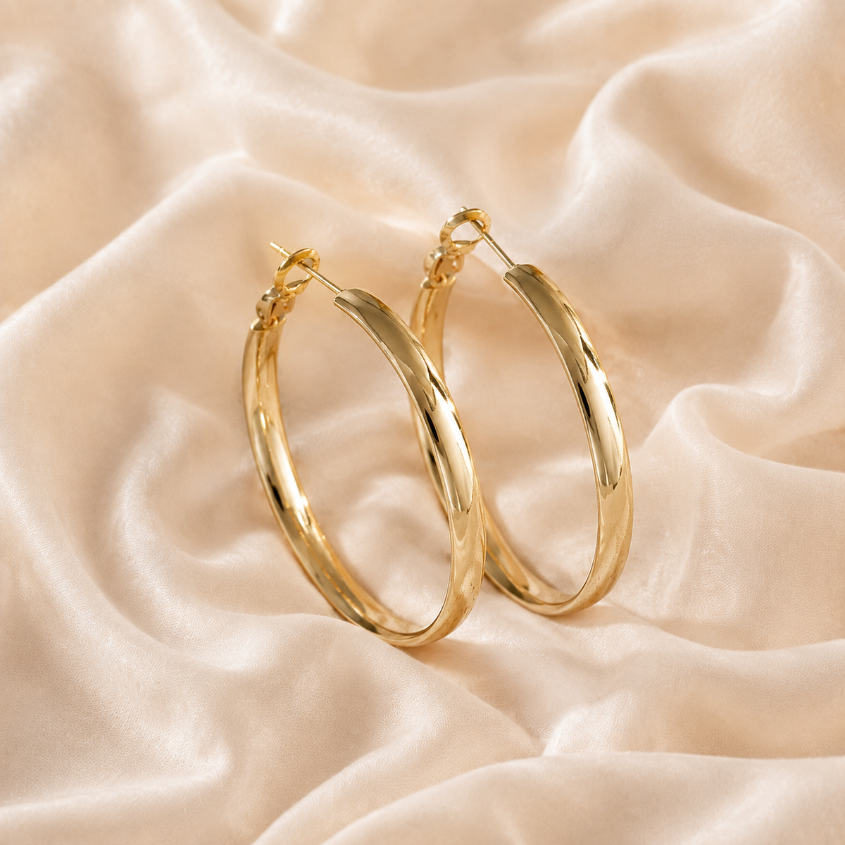 Heatfold Hoop Earrings styled on warm cream silk