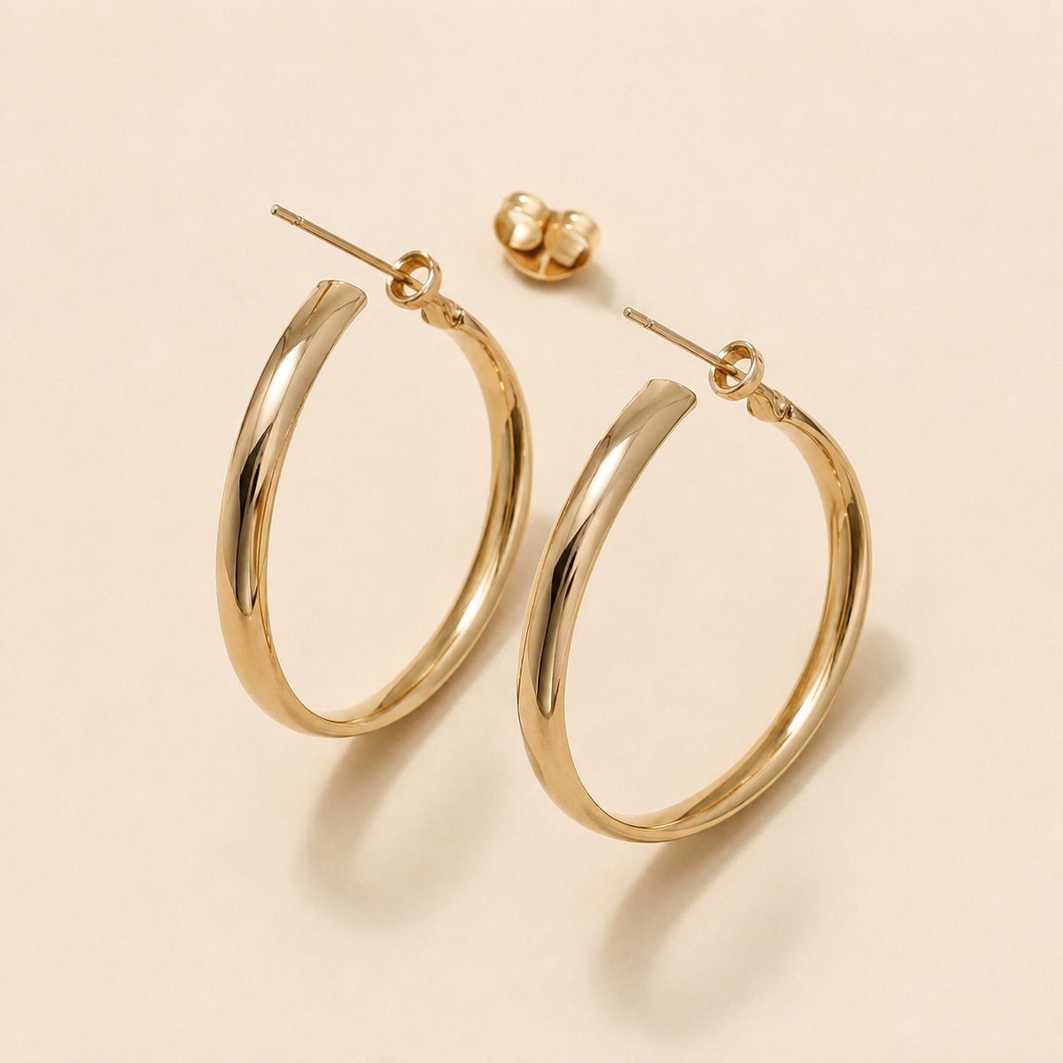 Close-up of the gold-tone elongated oval hoop design with a smooth reflective finish