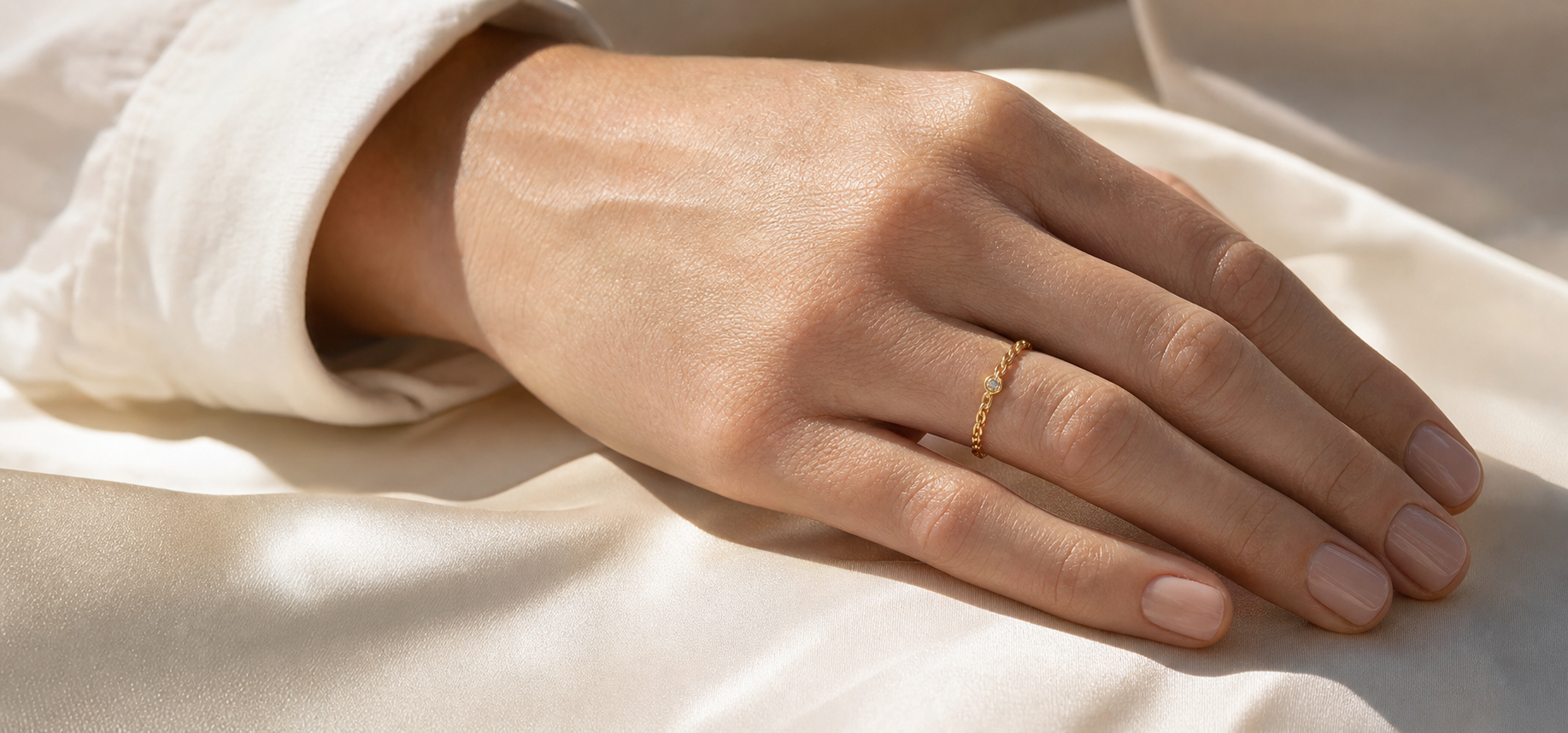 Editorial hand view of Golden Link Solitaire Ring in soft shell-toned styling