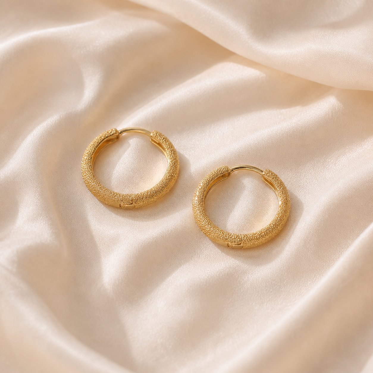 Gold-tone textured huggie earrings on Moonveil cream silk