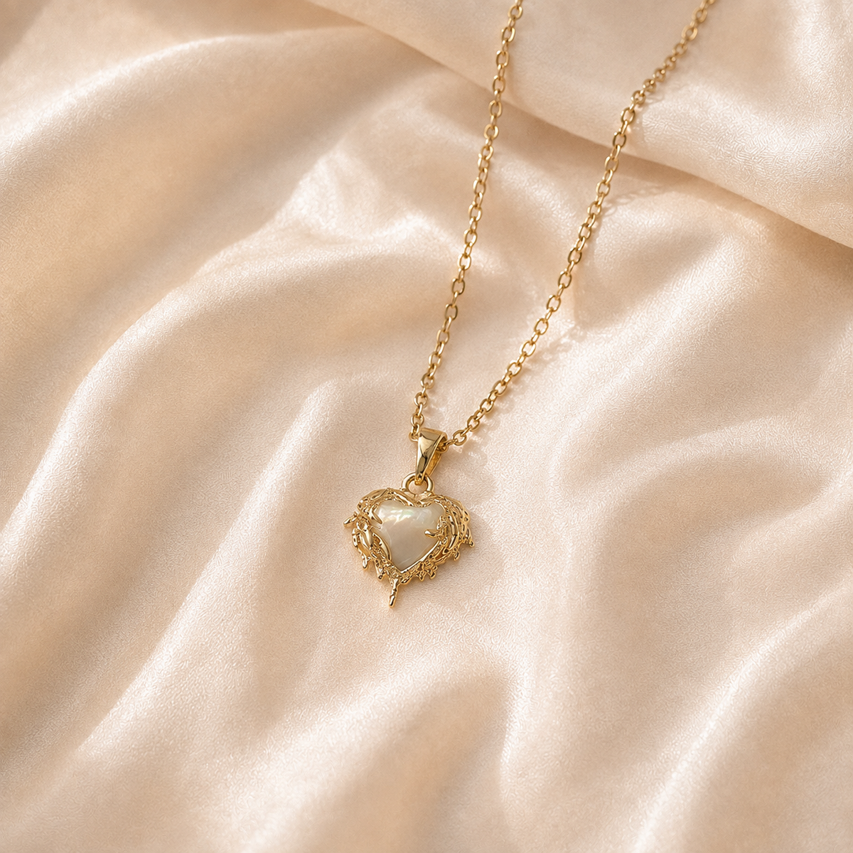 Candlelit Flame Pendant Necklace with a pale cream-white iridescent heart centre on cream silk.