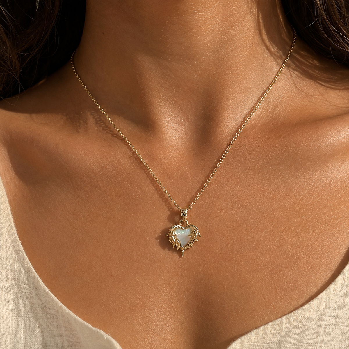 Candlelit Flame Pendant Necklace worn at the collarbone, with its pale heart centre and ornate gold-toned frame visible.