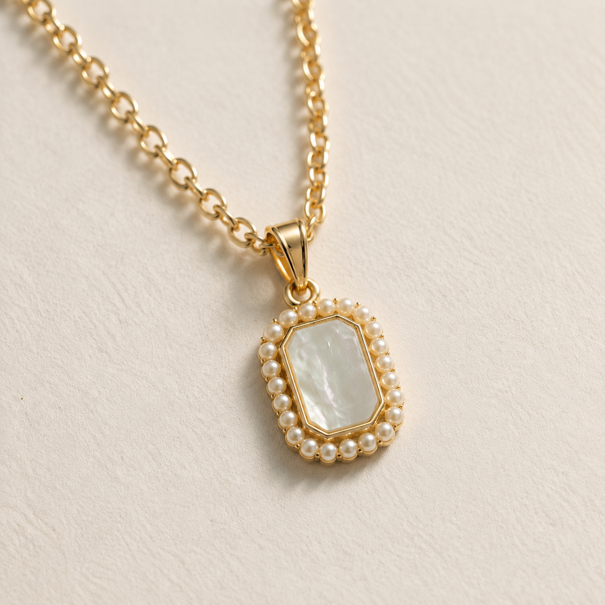 Close view of the Folio Frame pendant, tapered bail, pale centre, and white bead-like border