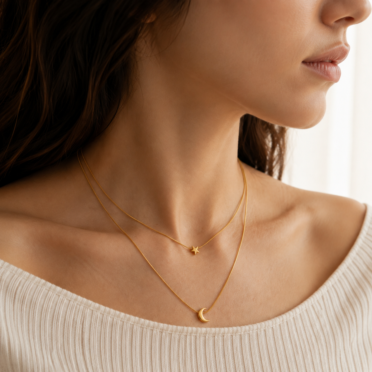Side-profile upper-chest view of a two-layer gold-toned necklace with a star above a right-opening crescent.