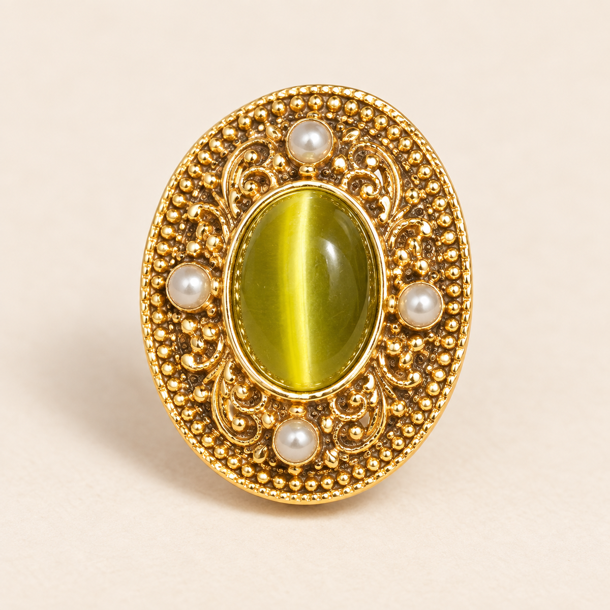 Close view of an ornate warm-tone earring with an olive-green oval center and pale round accents