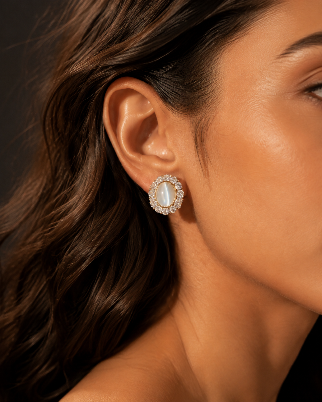 Editorial side profile of a Celestial Keep Earring with a pale oval center and surrounding halo-like details