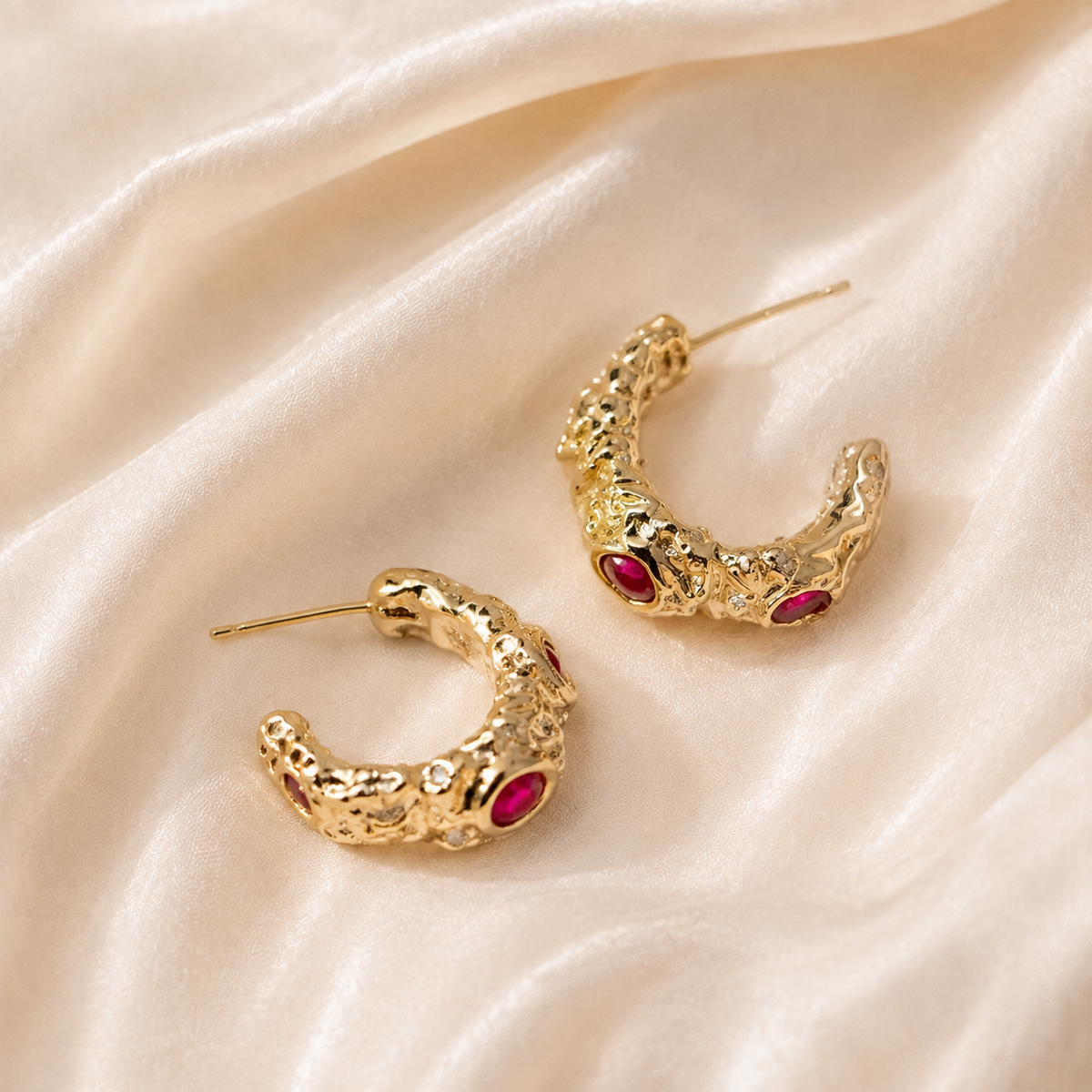 Pair of Vermilion Contour Earrings with open warm-tone curves and deep red accents on cream silk